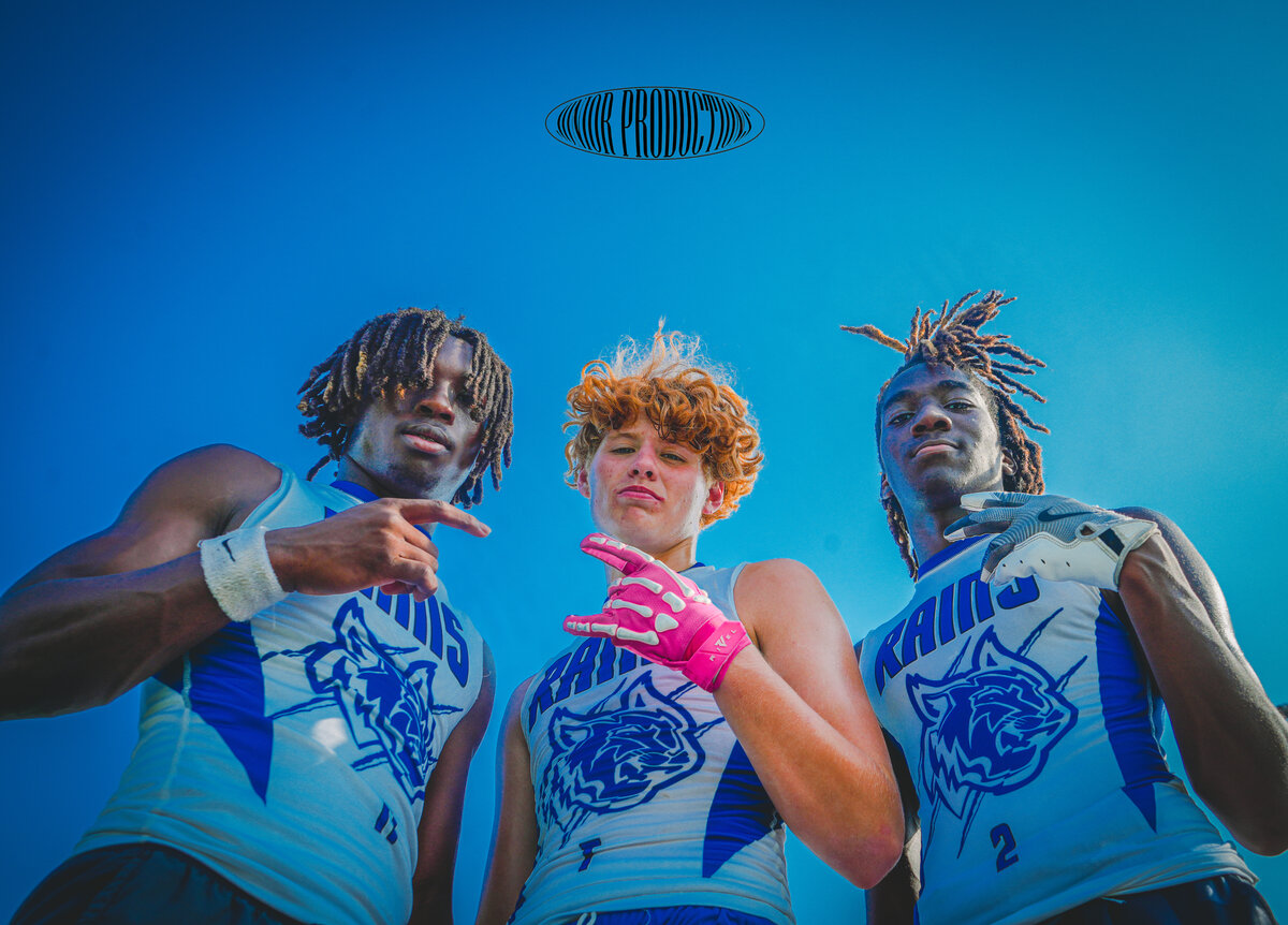 Three football players posing on the field